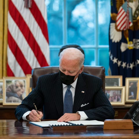 President Joe Biden signs an Executive Order rever