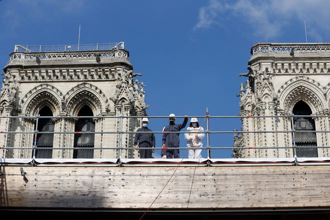 French President Emmanuel Macron, center, visited Notre Dame Cathedral Thursday to check on the progress of restoration efforts two years after fire tore through the church.