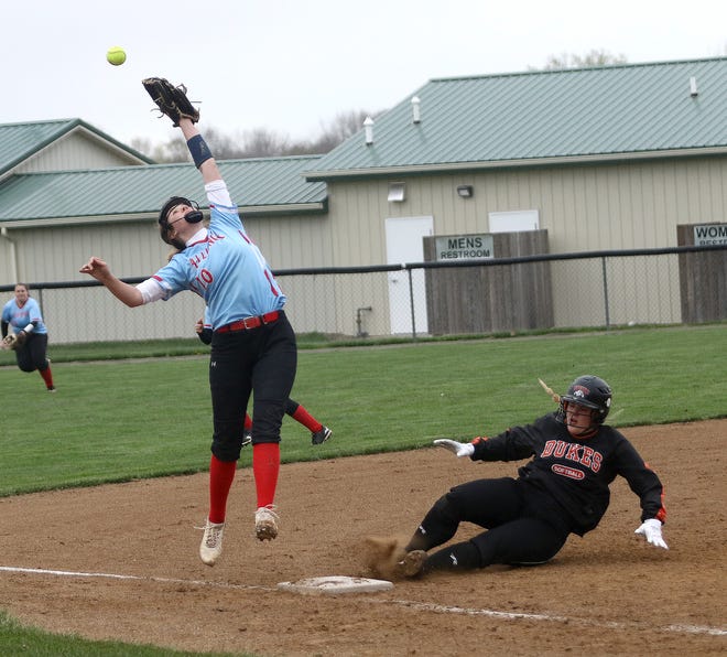Marlington's Emma Jackson, right, slides safely into third base against Alliance in a game in April 2021.