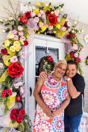 Kathy Austin and Angela Boudreaux stand outside Austin's decorated front door on Lafayette Street in Houma. They've been working together for years, and their designs are a collaborative effort.