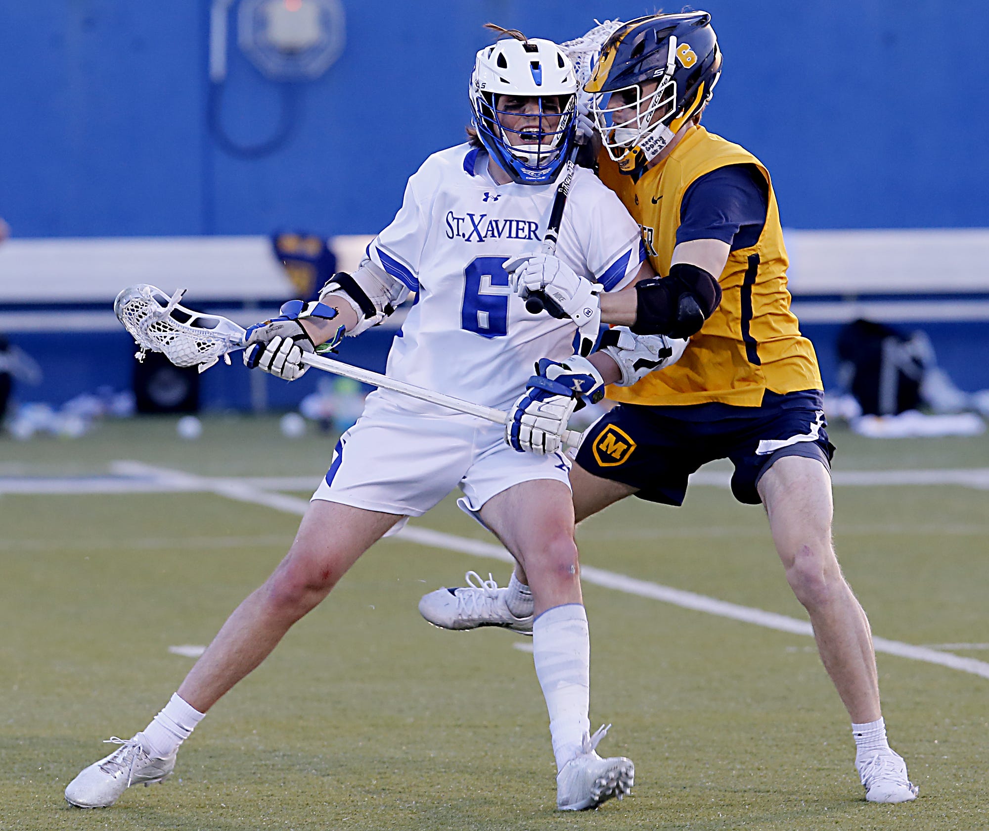 St. Xavier High School midfielder Joel Regruth is checked by Moeller midfielder Lane Miller during a Greater Catholic League South lacrosse game at St. Xavier April 16, 2021. Moeller won 10-6.