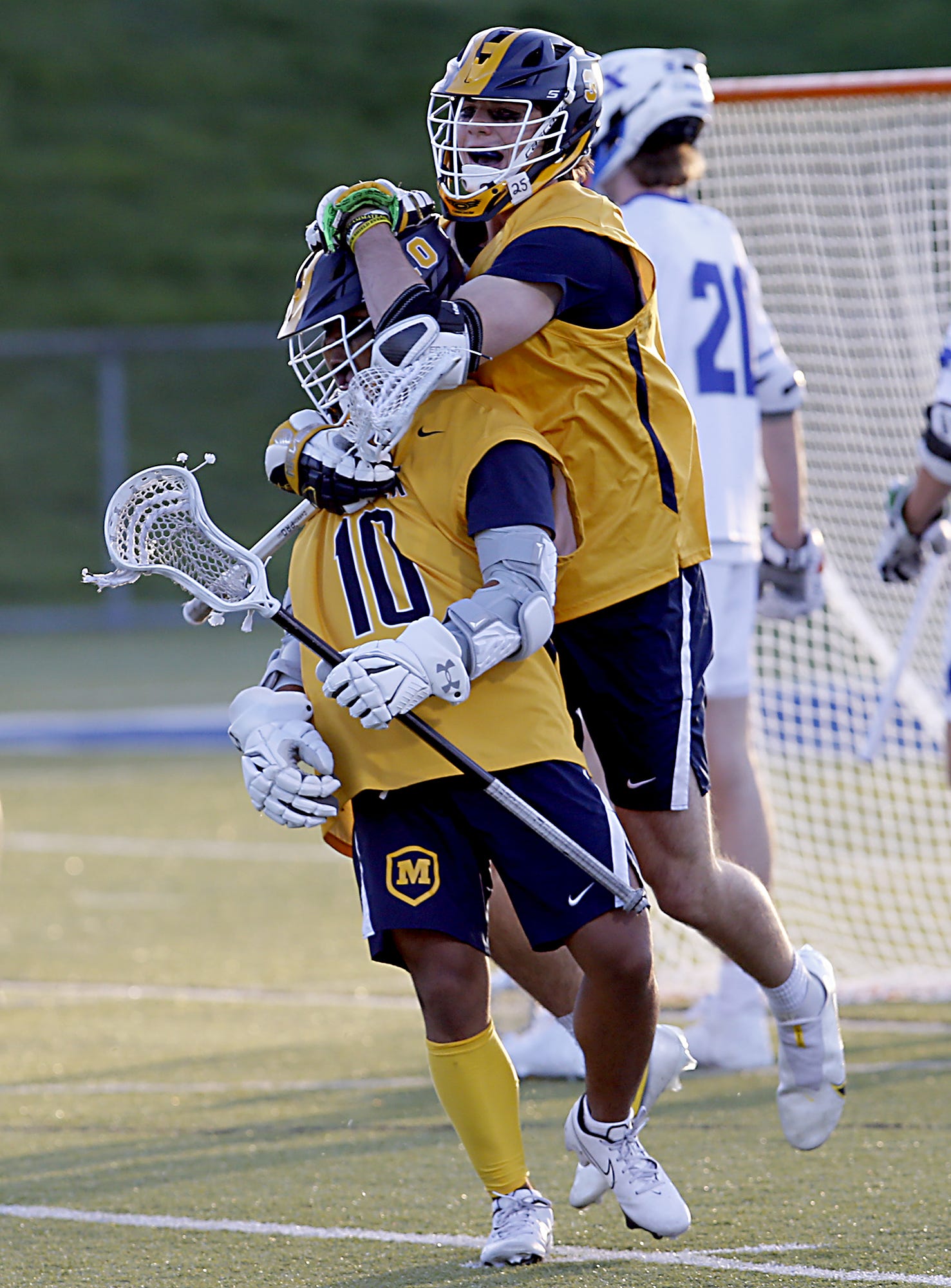 Moeller High School attacker Zach Wendling (10) is congratulated by teammate Nolan Malone after Wendling scored against St. Xavier during a Greater Catholic League South lacrosse game at St. Xavier April 16, 2021. Moeller won 10-6.