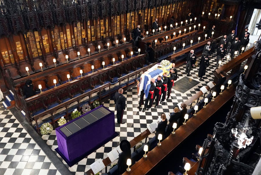 Britain's Queen Elizabeth II watches as pallbearers carry the coffin of the Duke of Edinburgh during his funeral at St. George's Chapel in Windsor Castle.