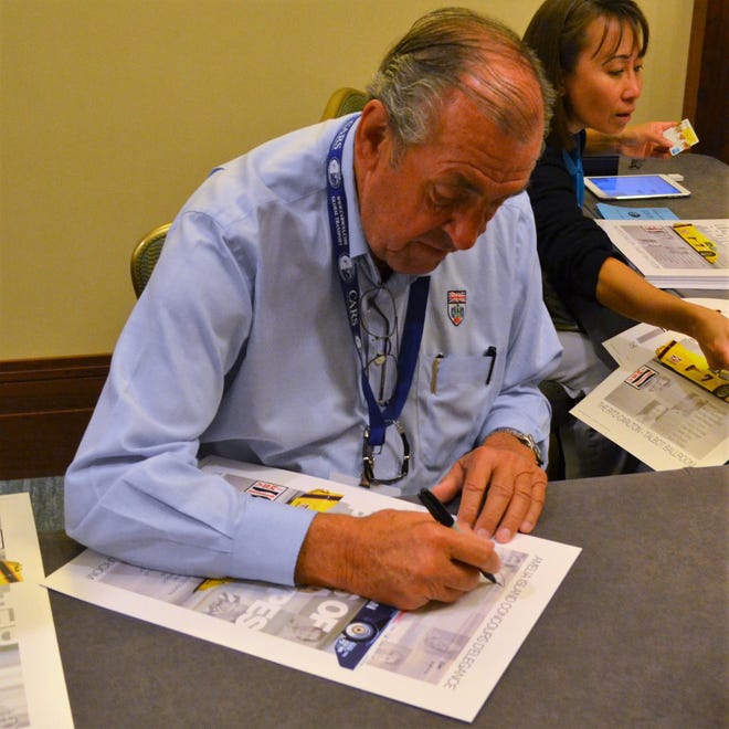 British race car driver David Hobbs signing copies of his autobiography at last year's Amelia Island Concours.