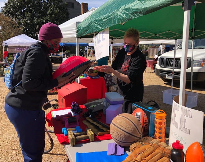 On the right, Heather Marston with Little Creek Kung Fu hands Lucinda Patterson of Petersburg a free bosu ball during the River Street Market