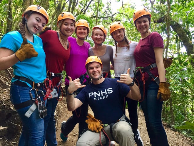 Plymouth North High School math teacher Alex Cardoso, kneeling with students during a past trip to Costa Rica, will co-lead students to Peru during spring break in 2023.