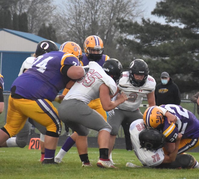 Orion’s Jayson Johnson (72), far right, drags down the Sherrard runner on a third down play as the first quarter ends on Friday, April 16, on the Tiger field. Johnson kept Sherrard from getting a first down on the play, and the Tigers had to punt. Also in on the play are, standing from left, Josh Fair (65) and Coby Schultz (2)