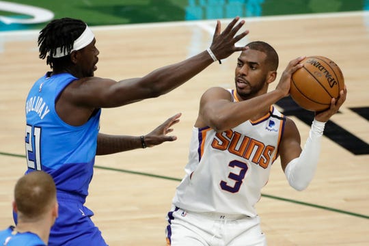Phoenix Suns' Chris Paul, right, drives to the basket against Milwaukee Bucks' Jrue Holiday, left, during the second half of an NBA basketball game Monday, April 19, 2021, in Milwaukee. (AP Photo/Aaron Gash).