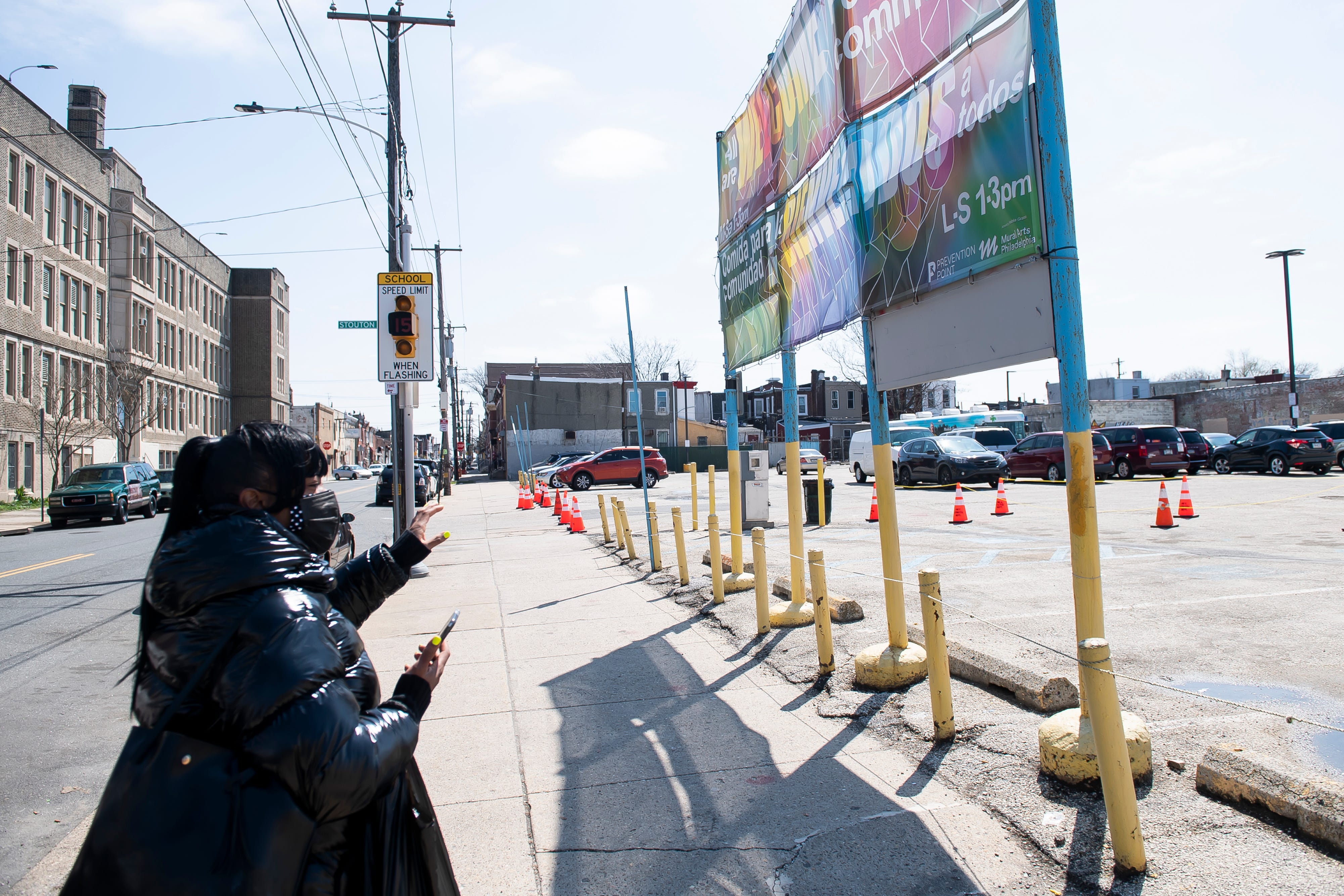 Tina Moore walks toward a community food and medicine distribution site that is organized by several nonprofits, including Prevention Point Philadelphia, in Kensington on April 1, 2021.