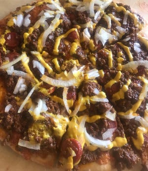 Include il Pizza Café di Yia Yia "Connie Islander" Con hot dog, condito con salsa per hamburger Cone Island, servito con cipolla e senape a scelta.