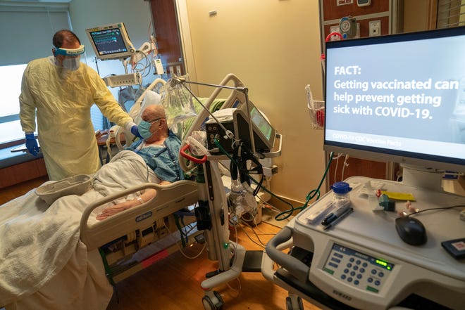 Dr. David Vandenberg checks on the comfort of John Collins, 84, of Milan as Collins recovers from Covid related symptoms at St. Joseph Mercy Hospital in Ypsilanti on April 20, 2021.