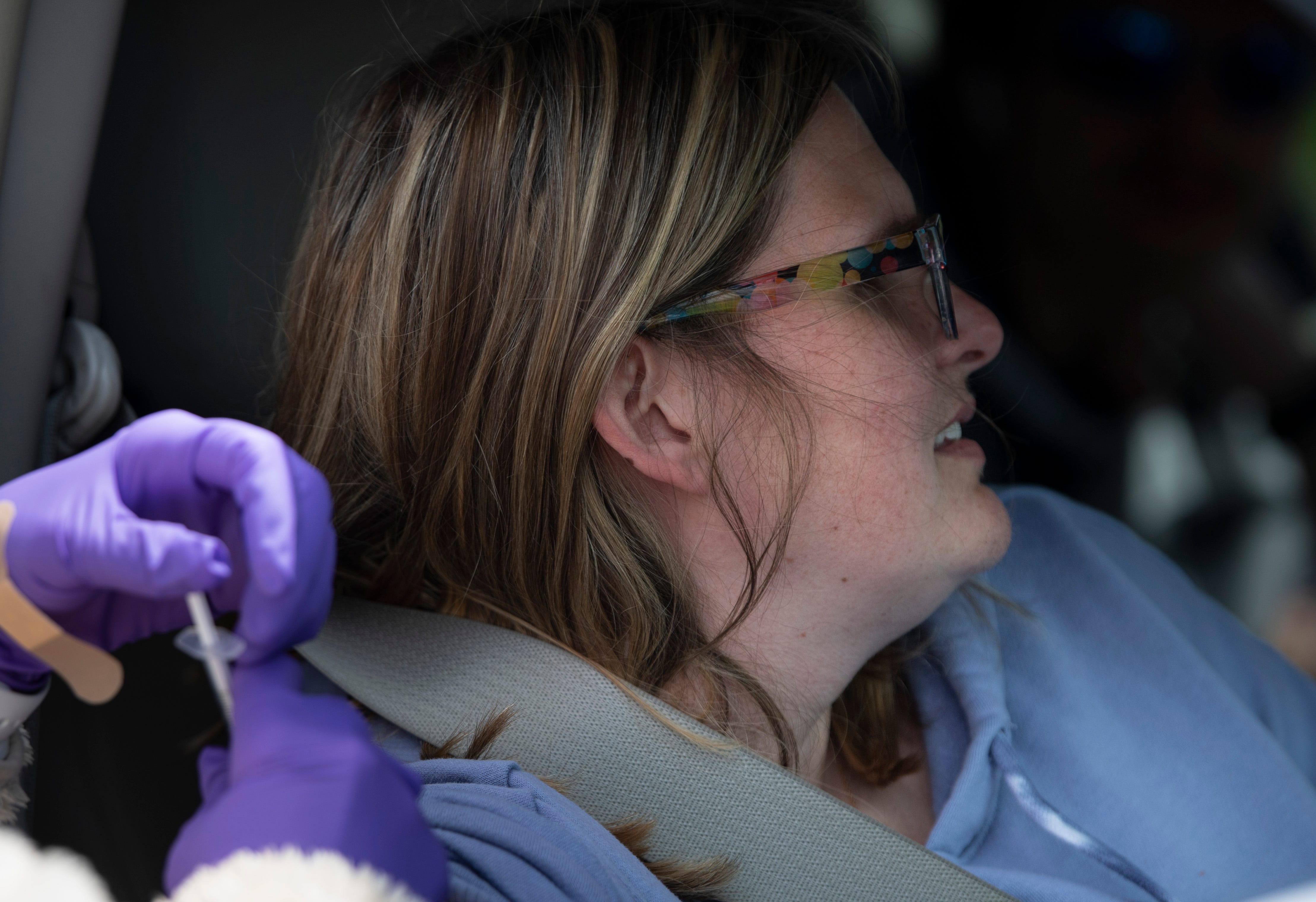 Brianne Slusher, of Portland, Tennessee looks away as she receives a COVID-19 vaccine at a pop-up vaccination clinic on April 22, 2021. The church partnered with Adhere Rx to boost the vaccination efforts in the rural area.
