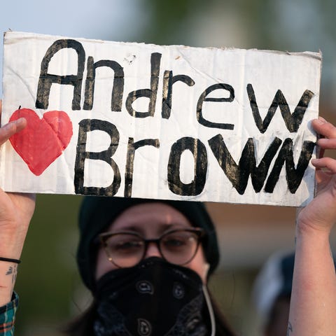 A demonstrator holds a sign for Andrew Brown Jr. d
