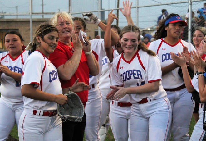 Cooper softball players including Jahlissah Marquez, left, and Summer Simmons, flanking coach Stacey Herring, celebrate after downing Wylie 4-0 at the Lady Coogs' ballpark on Friday for their 20th win of the season. Both teams are bound for the Class 5A playoffs.