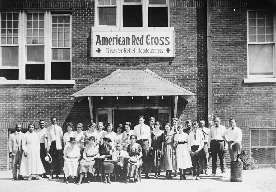 Staff members stand in front of the American Red Cross Disaster Relief Headquarters in Tulsa after the race massacre of June 1921.