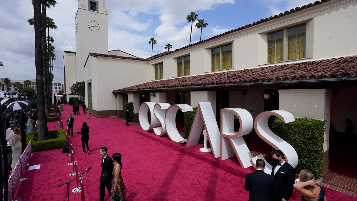 Lee Isaac Chung, left, and Valerie Chung are interviewed on the red carpet at the Oscars on Sunday, April 25, 2021, at Union Station in Los Angeles.