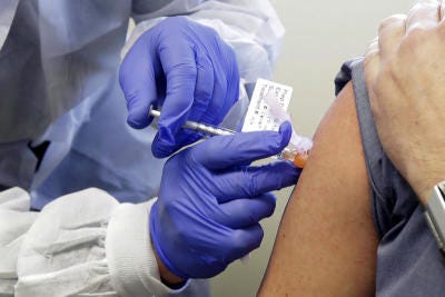 An individual receives a COVID-19 vaccine shot.