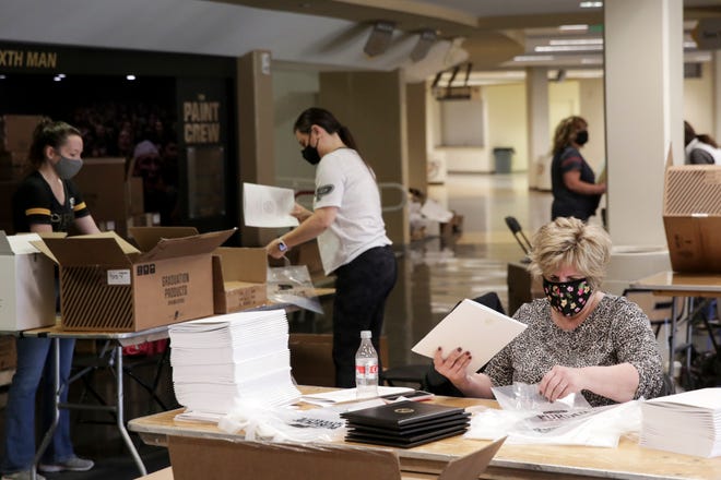 Purdue University workers prepare commencement bags for graduates to receive after their outdoor ceremony in two weeks, Monday, April 26, 2021 in West Lafayette.