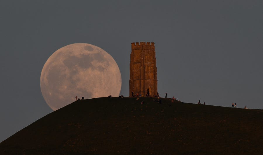 The full moon rises behind Glastonbury Tor on April 26, 2021 in Glastonbury, England.