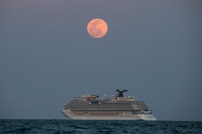 The Carnival Vista cruise ship is seen sailing during a full Pink Super moon in Miami Beach, on April 26, 2021.