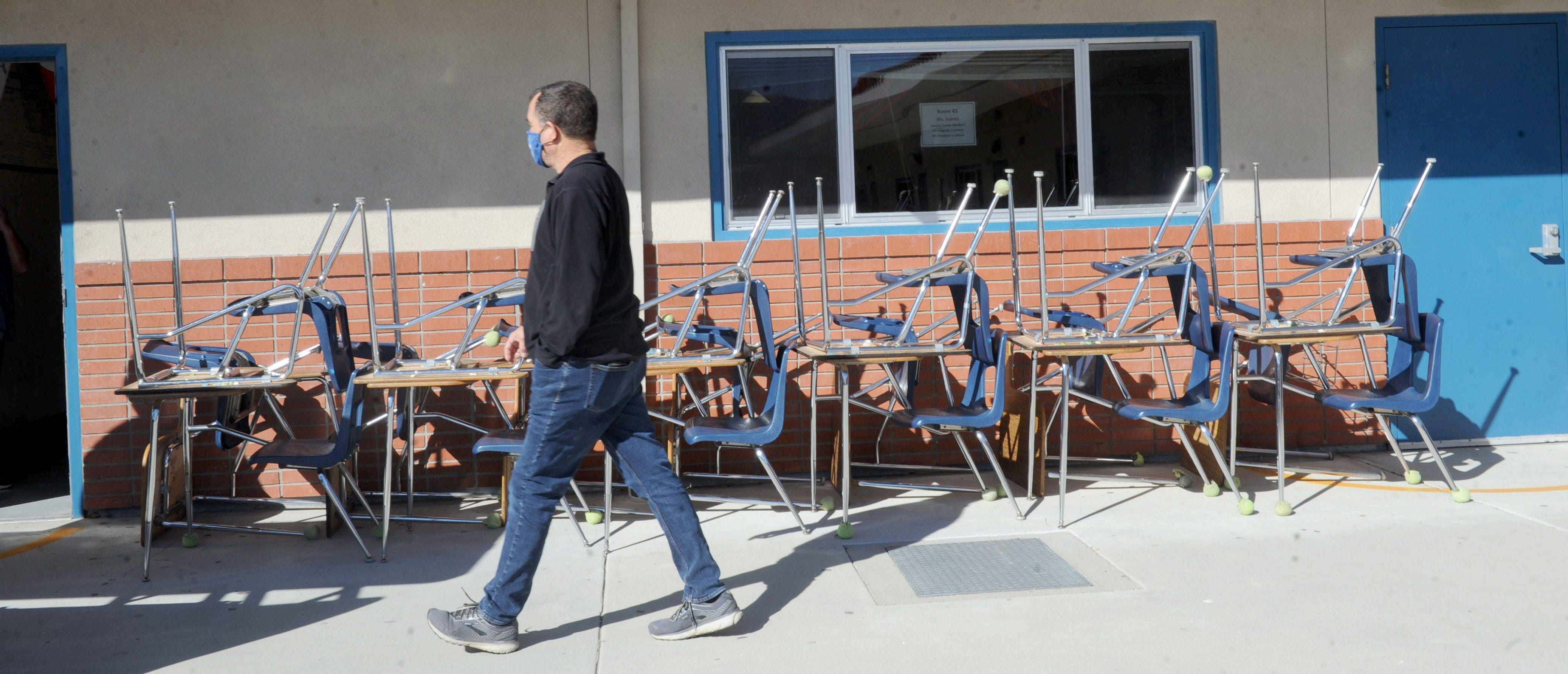 Fillmore High School Principal John Wilber walks across the closed campus where some desk sit outside on Friday, Feb. 05, 2021. The California high school has been closed since March 2020.