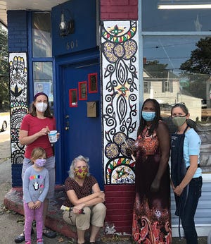 Henna artist Nialwak Athow, second from right, shows off her mural on Lake Erie International Market, 601 Brown Ave. With her are Kelly Armor, center, folklorist in residence for Erie Arts & Culture, which received a grant for the project; Mary Elizabeth Meier, left, art education professor at Edinboro University, and her daughter, Abigail Meier; and Jennifer Peters, art educator in the Fort LeBouef School District. Mary Elizabeth Meier and Peters helped with the mural.