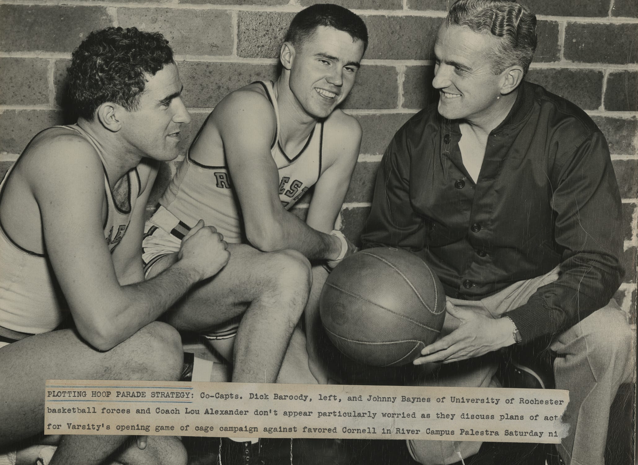 In 1946, months after returning home from service, Dick Baroody (left) and Johnny Baynes (middle) rejoined coach Lou Alexander (right) as co-captains of the basketball team. This photo was taken before the 1946-47 season opener against Cornell.