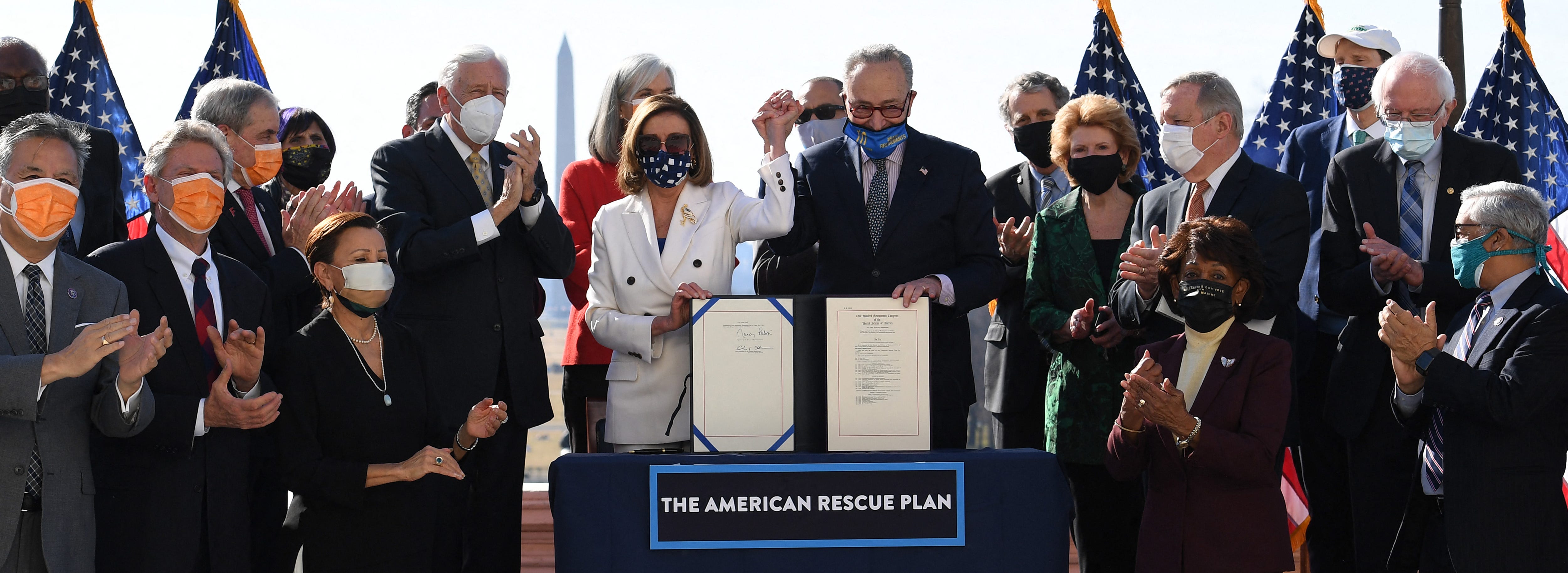 Speaker of the House Nancy Pelosi and Senate Majority Leader Chuck Schumer hold the signed American Rescue Plan Act after the House Chamber voted on the final revised legislation of the $1.9 trillion COVID-19 relief plan, at the U.S. Capitol on March 10, 2021, in Washington.