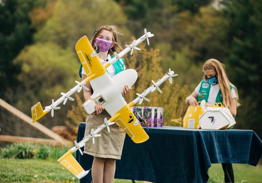 Girl Scouts Gracie Walker and Alice Goerlich help prepare orders with Wing for drone cookie deliveries in Christiansburg, Va.