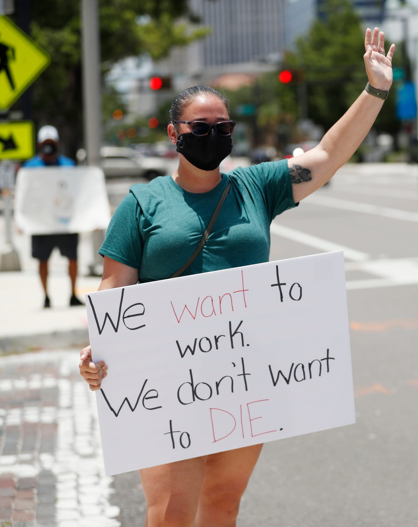 Middle school teacher Danielle Weigand stands in protest in front of the Hillsborough County Schools District Office on July 16, 2020, in Tampa, Fla. Teachers and administrators from Hillsborough County Schools rallied against the reopening of schools due to health and safety concerns amid the COVID-19 pandemic.