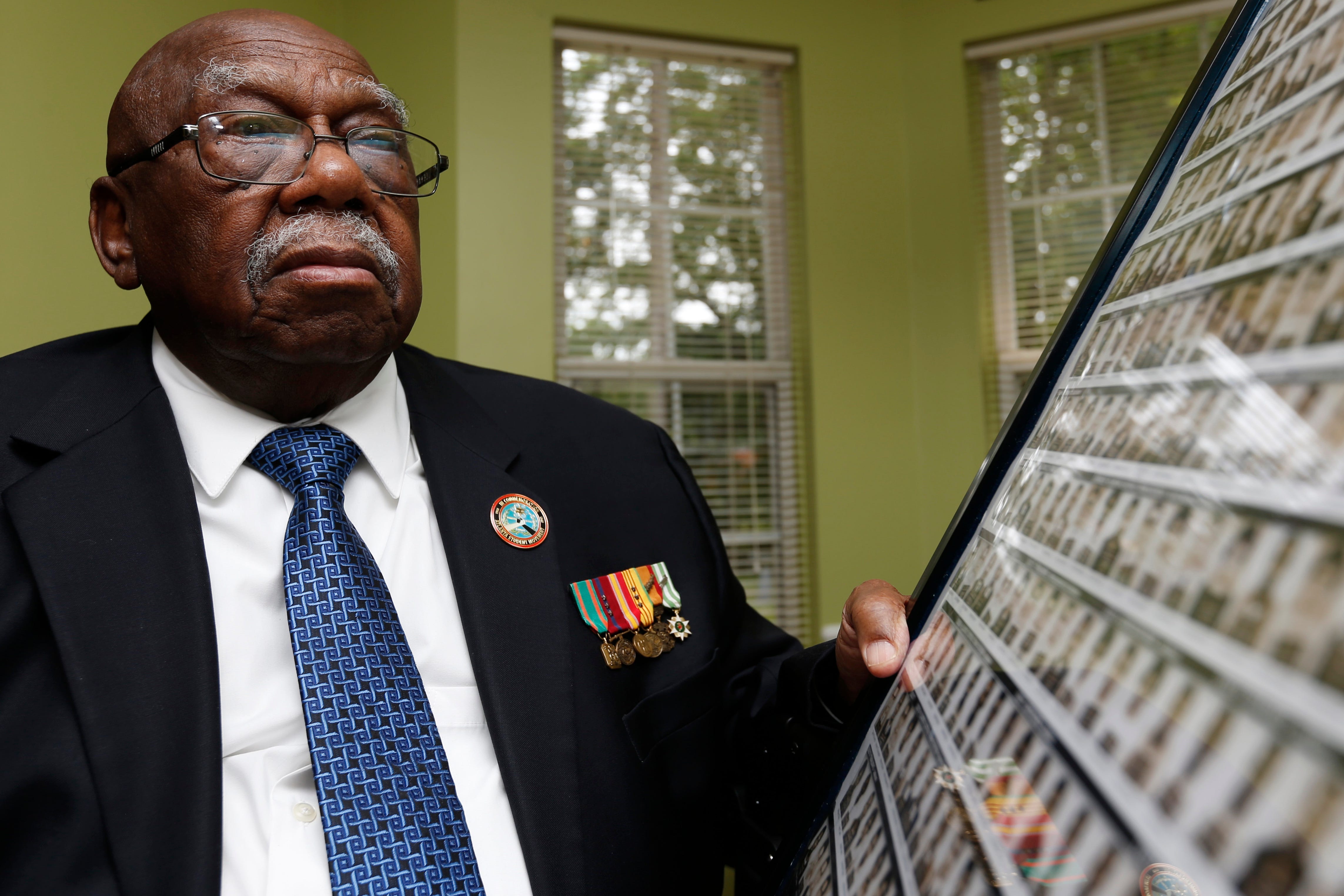 Charles Person, one of the original 13 Freedom Riders, with a poster made from the mugshots of Freedom Riders arrested in Mississippi in 1961, photographed at his home in Atlanta on April 29, 2021.