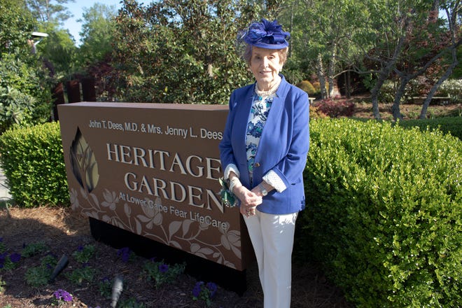 Jenny L. Dees stands next to newly installed sign at Lower Cape Fear LifeCare’s Wilmington garden entrance.