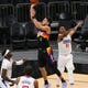 Phoenix Suns guard Devin Booker (1) shoots while defended by LA Clippers guard Terance Mann (14) during the third quarter in Phoenix April 28, 2021.