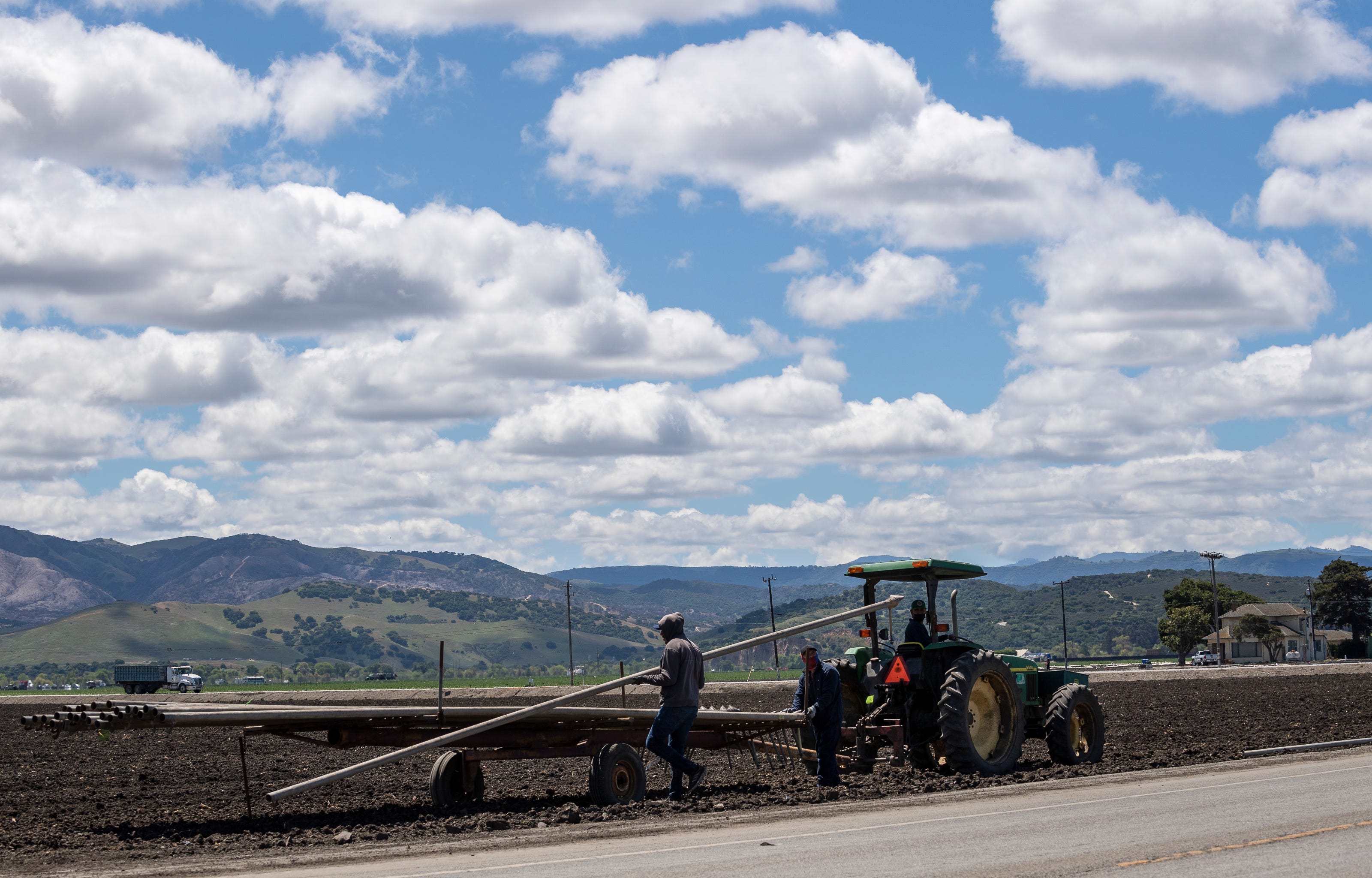 Early morning on Monday, April 26, 2021, farm workers in Salinas, California will pick up irrigation sprinklers. 