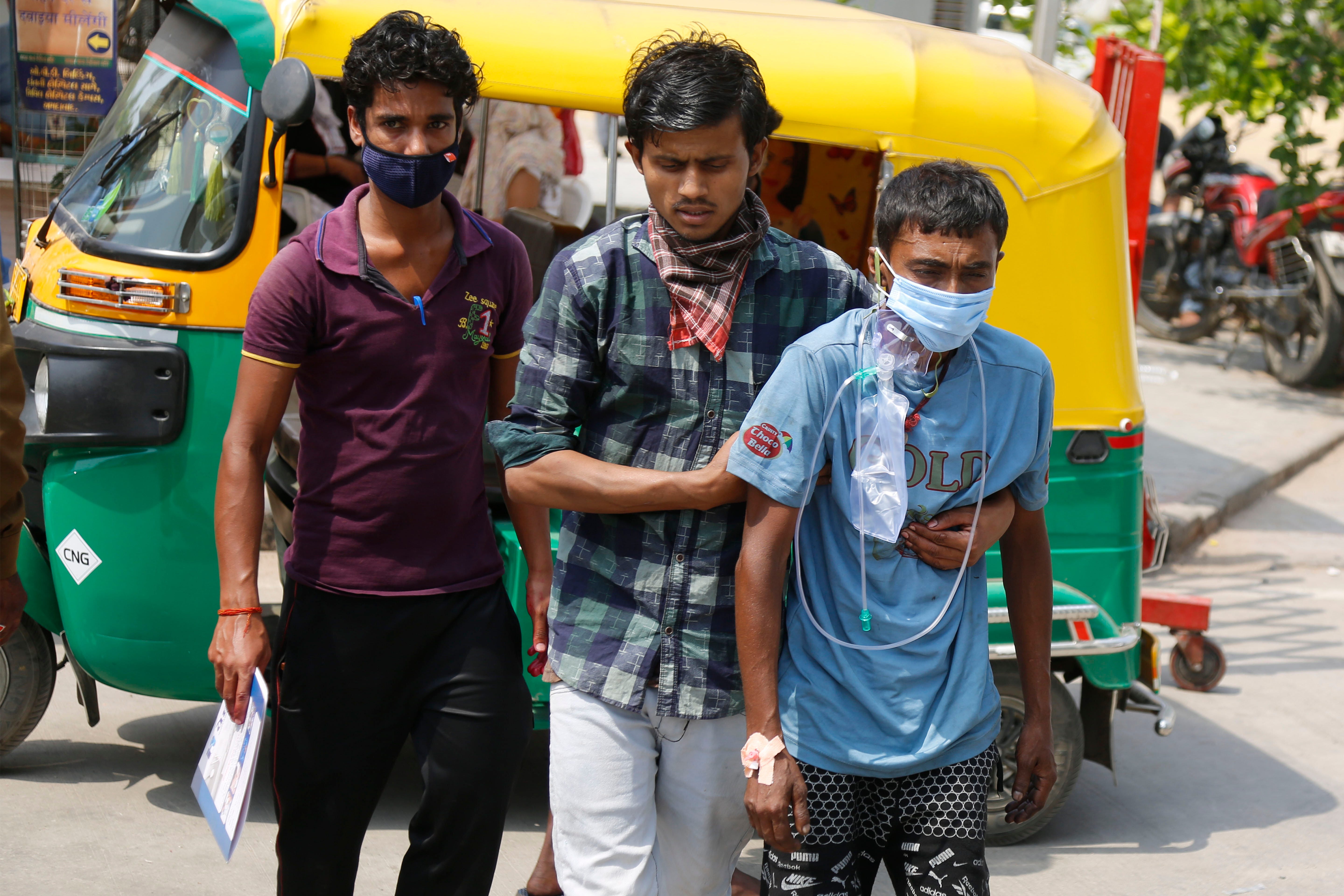 Relatives arrive with a COVID-19 patient at a dedicated COVID-19 government hospital in Ahmedabad, India,  April 27, 2021. Coronavirus cases in India are surging faster than anywhere else in the world.