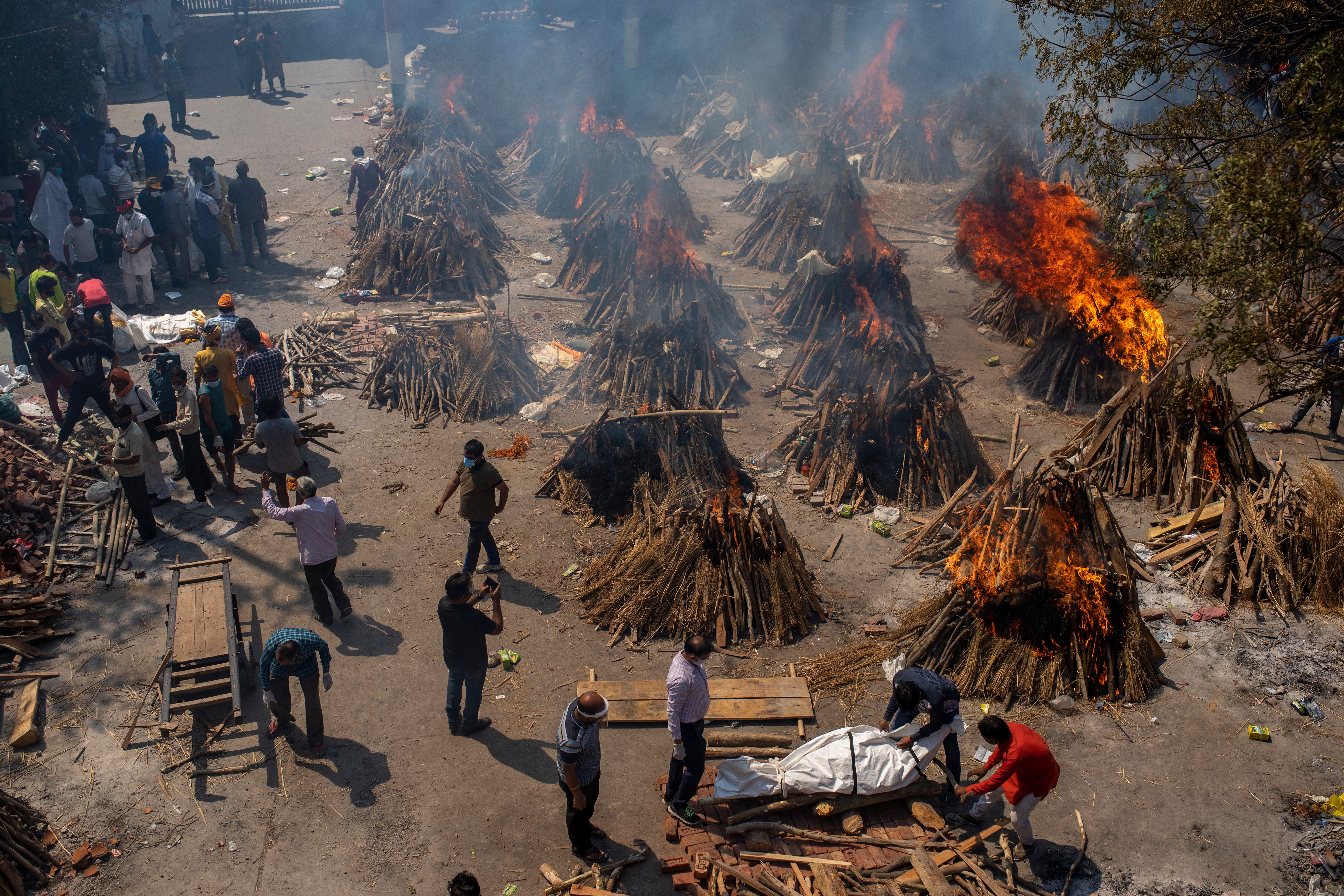 Multiple funeral pyres of victims of COVID-19 burn in an area that has been converted for mass cremation in New Delhi, India, Saturday, April 24, 2021.
