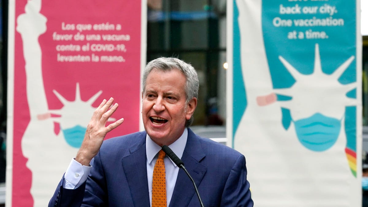 In this Monday, April 12, 2021 file photo, New York Mayor Bill de Blasio delivers remarks in Times Square after he toured the grand opening of a Broadway COVID-19 vaccination site intended to jump-start the city's entertainment industry, in New York. Blasio expects the city to 