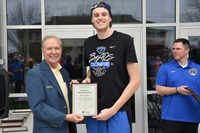 Des Moines Area Community College men’s basketball player Ryan Schmitt, of Van Meter, was recently presented with a plaque by DMACC President Rob Denson. Pictured, from left: Rob Denson and Ryan Schmitt.