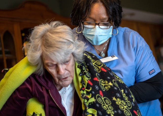 Excellacare Care Provider Sarah Sutherlin helps her client Carmela Palamara, 92, of Brownstown stand up to stretch her legs after the two color and play a game of UNO at Palamara's home on April 14, 2021.