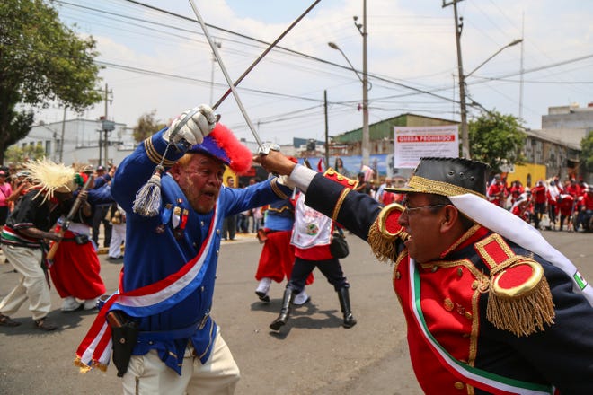 A man dressed as a French soldier, at left, and one dressed as a Mexican soldier, at right, sword fight during a reenactment of The Battle of Puebla between the French army and Zacapoaztlas as part of Cinco de Mayo celebrations, May 5, 2019, in the Penon de los Banos neighborhood of Mexico City. Cinco de Mayo commemorates the victory of an ill-equipped Mexican army over French troops in Puebla on May 5, 1862.
