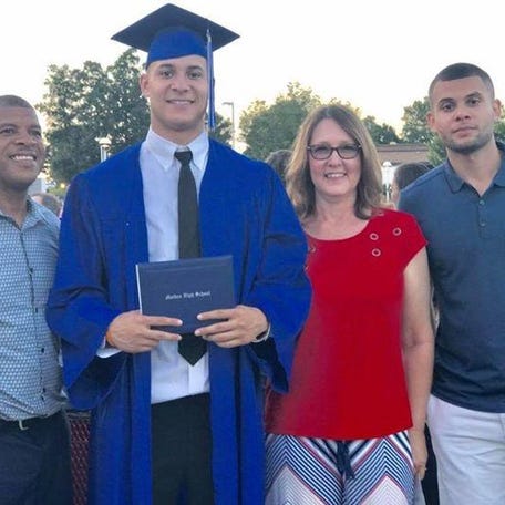 Caleb Farley stands with his cap, gown and diploma surrounded by his father, Robert (left), mother Robin and brother Joshua (right) during Caleb's high school graduation in Maiden, North Carolina in 2017. The Tennessee Titans selected the Virginia Tech cornerback in the first round (22nd pick) of the 2021 NFL Draft Thursday, April 27.