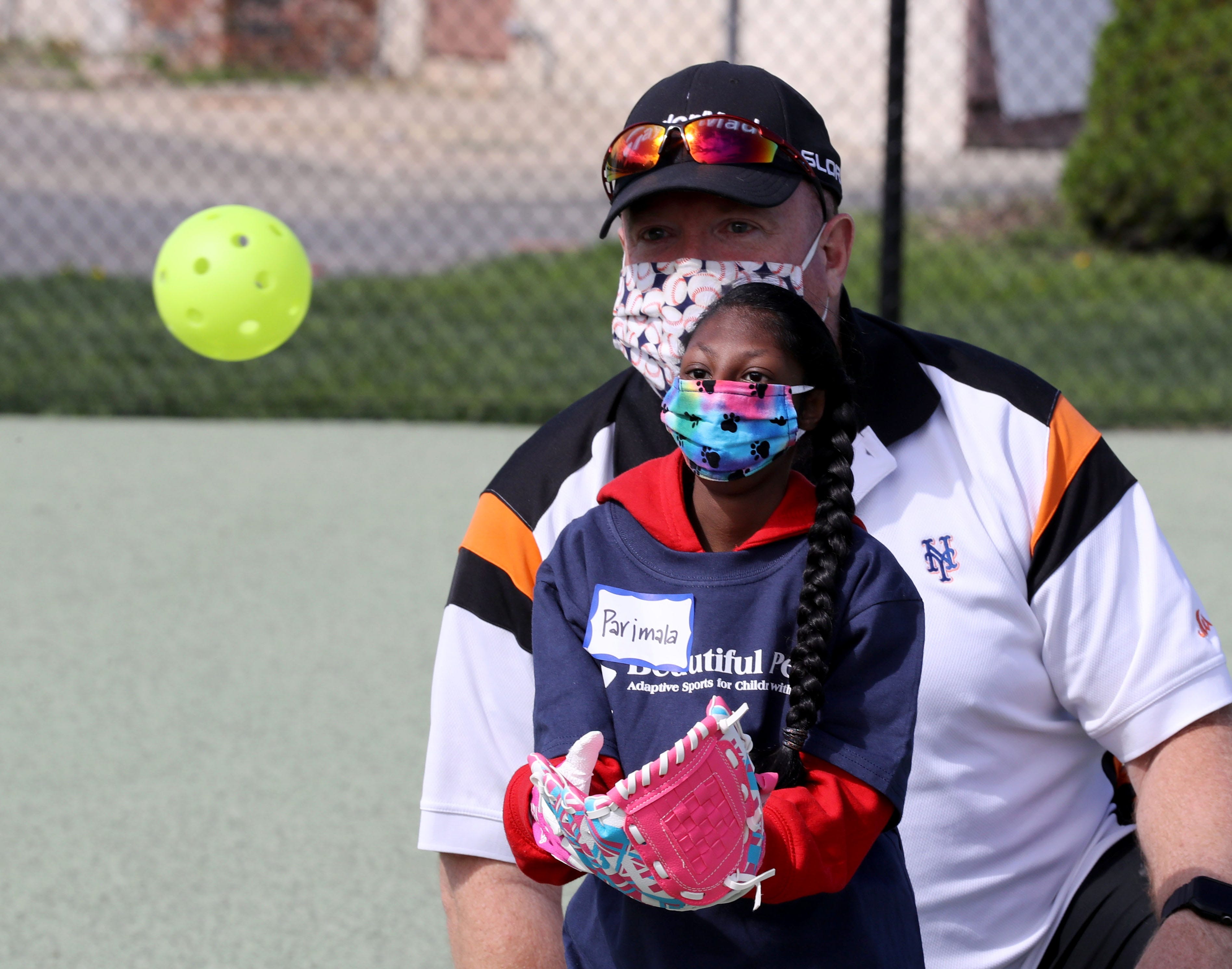 Parimala Cosgrove, 11, of Grahamsville, N.Y., is cheered on by her father, Tom, as she practices before opening day for Beautiful People Baseball in Warwick, N.Y., on May 2, 2021. The baseball program is one of the sports offered by Beautiful People, which provides adaptive sports for children with disabilities.