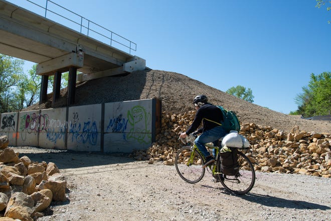 A cyclist begins to ride underneath a railroad bridge owned by BNSF on the Landon Trail off 33rd St.