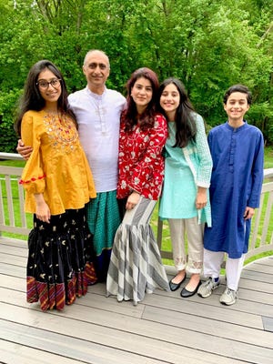 Mona Aslam (middle) stands with her family for holiday photos during last year's Eid al-Fitr. The Cherry Hill family spent the holiday praying at home, eating a home-cooked meal and dropping off gifts ar
ound town.