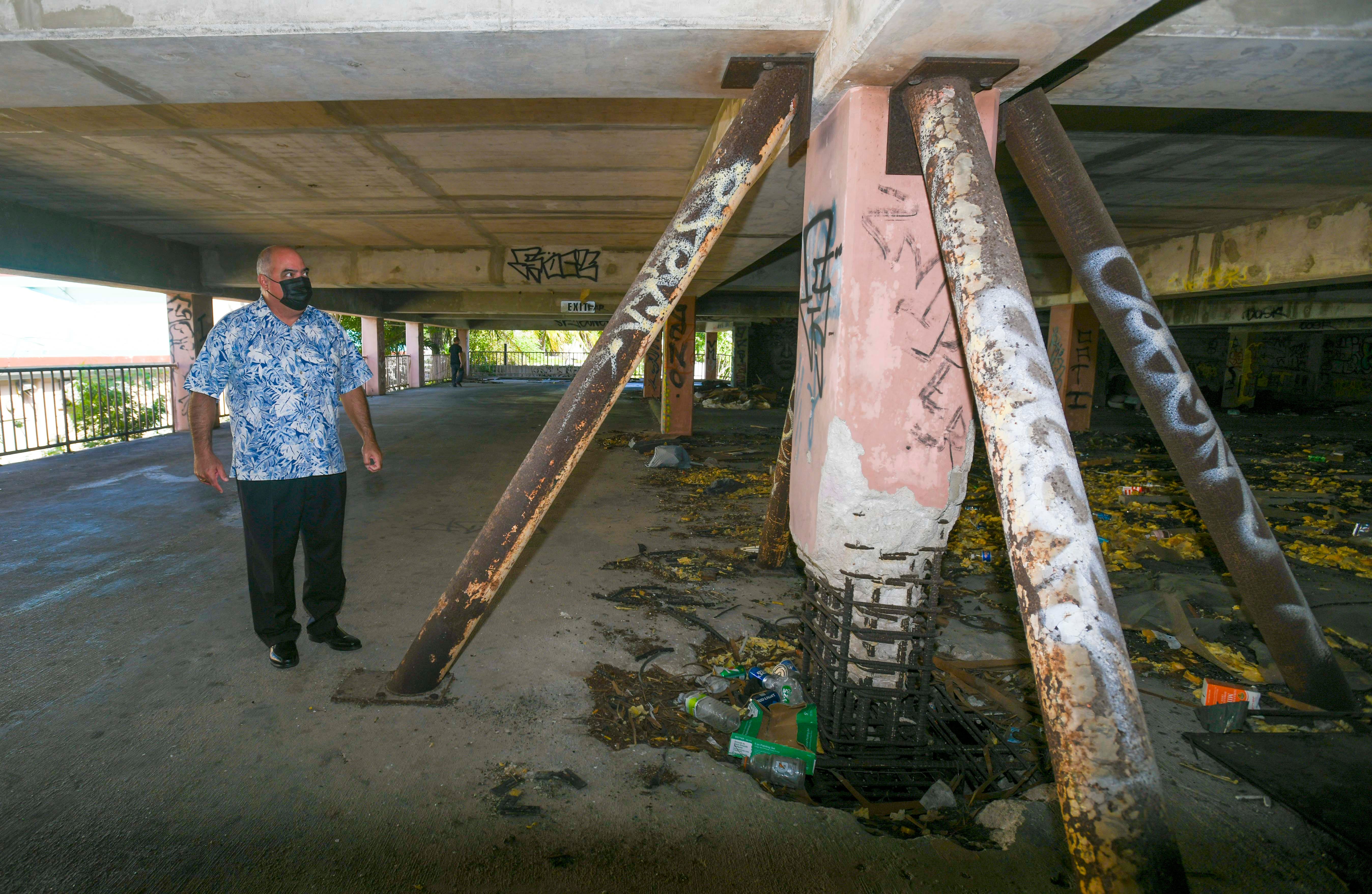 Sen. Chris Duenas takes a close up look of a weakened concrete support pilar he and others observed during a tour the abandoned parking garage of the former Royal Palms Resorts in Tumon on Wednesday, May 5, 2021.