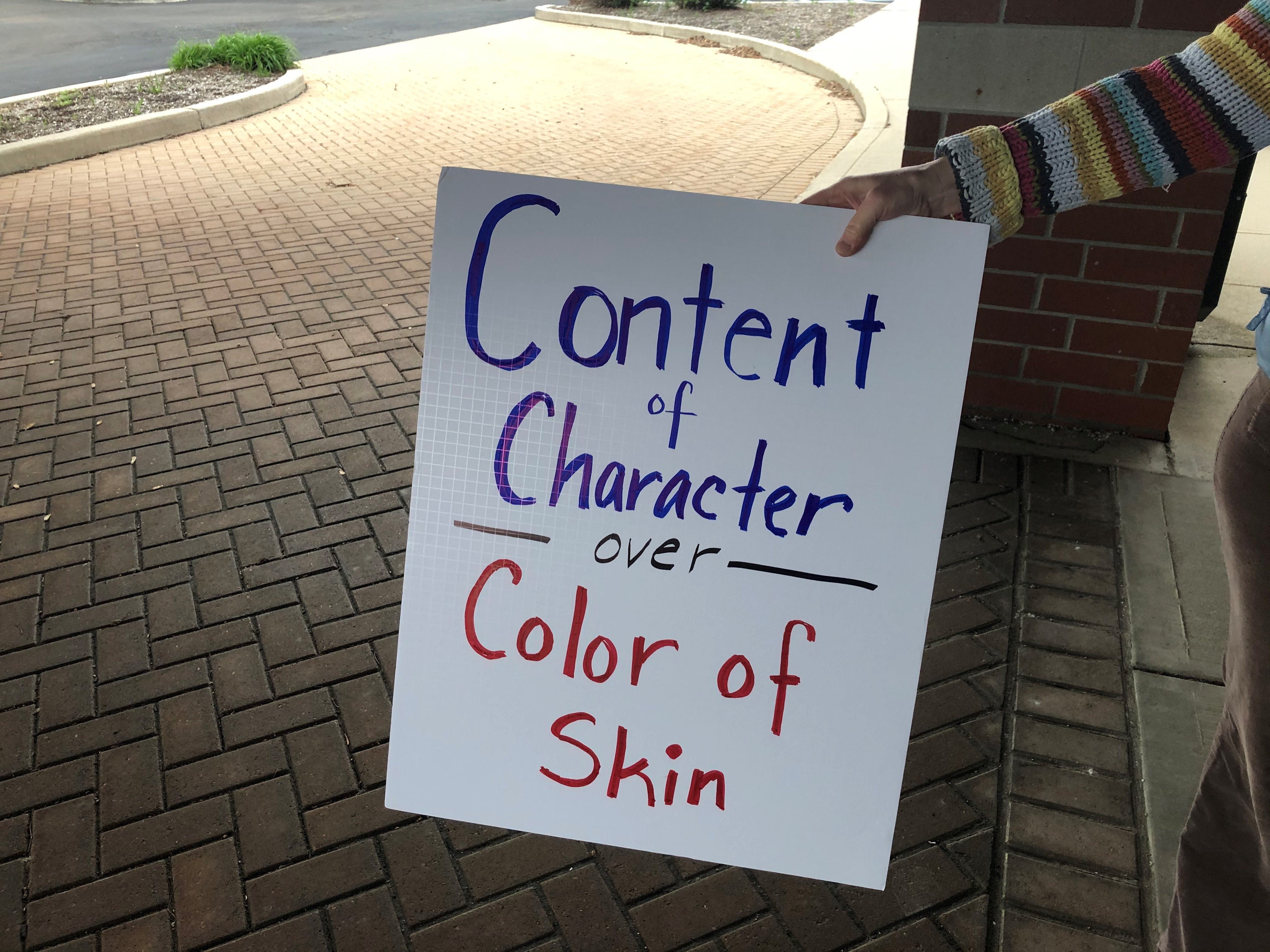 A protester holds a sign outside a building as the Noblesville school board meets inside on Tuesday, May 4, 2021. The protesters, who wouldn't provide their names, said they didn't want the schools to teach critical race theory, a concept that examines systemic racism as a part of American life. The district said it doesn't teach critical race theory.