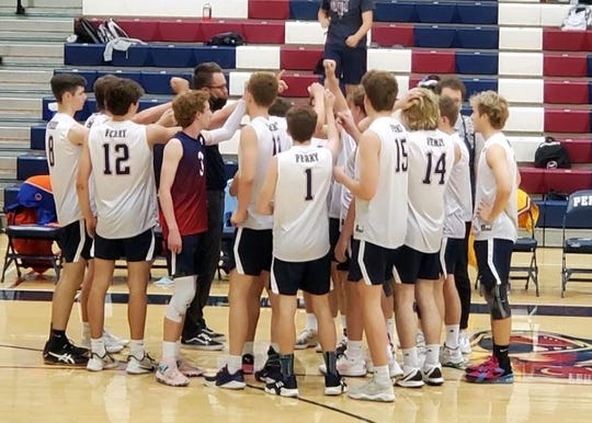 Perry High School's boys volleyball team gathers with coach Ryan Tolman during a recent match.