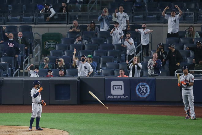 New York Yankees fans react as Houston Astros second baseman Jose Altuve tosses his bat after striking out to end the top of the third inning.