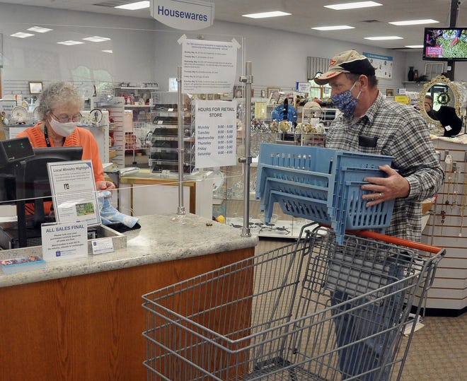 Volunteer Mary Etta Shilling rings up a purchase for Mark Yackey at MCC Connections in Kidron on May 6. The thrift store will celebrate its 20th anniversary on May 12.