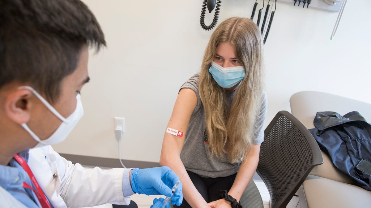 First student to receive a COVID-19 vaccine at the Ernest Mario School of Pharmacy POD is Jordan K. Clavida (SEBS '23) administered by Tin Le (EMSOP '21).